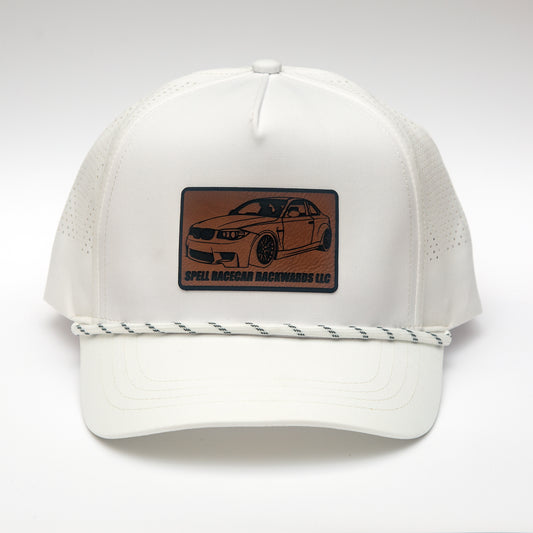 front view of white ball cap with leather patch with illustration of car, photographed on white background