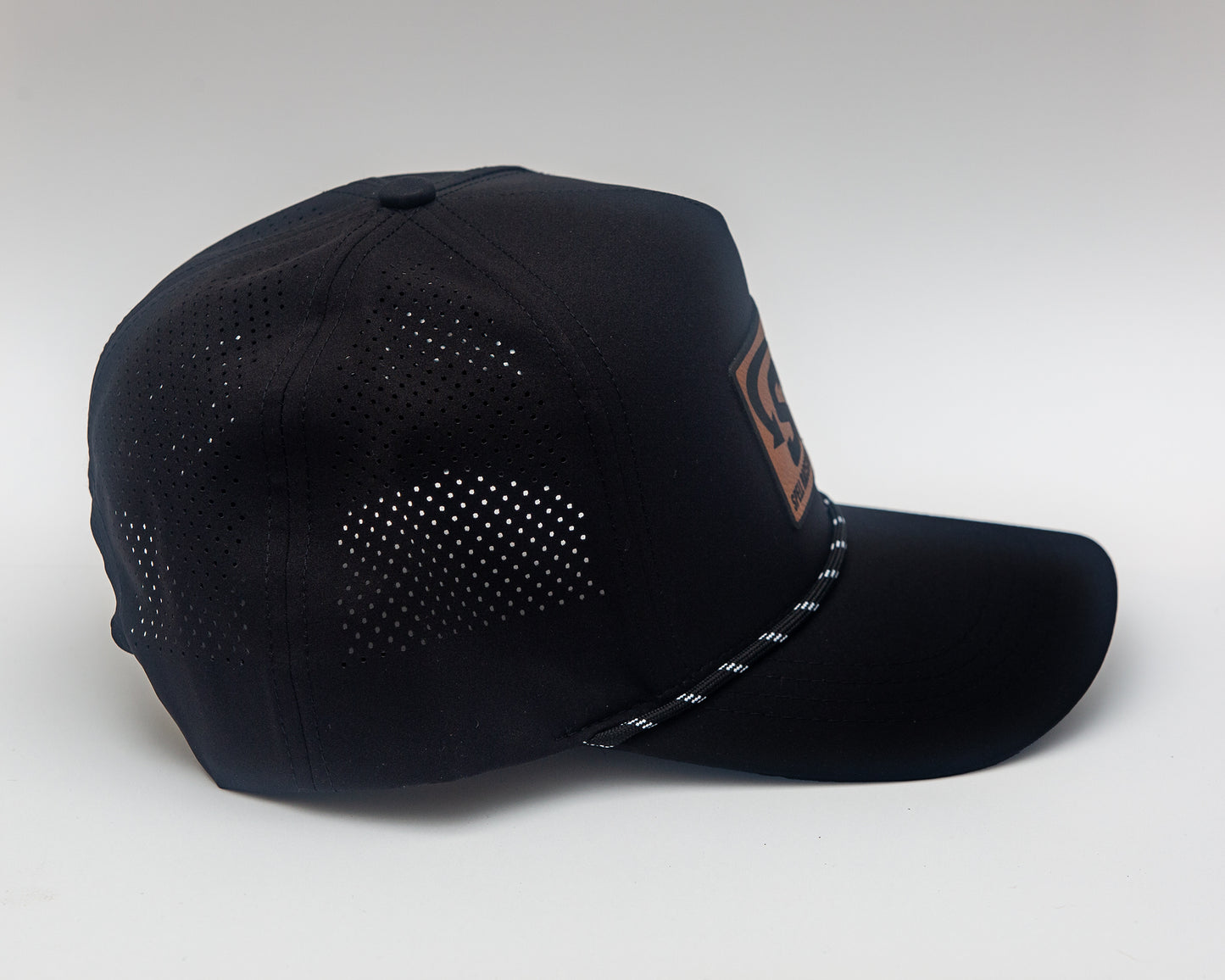 side view of black baseball hat with "SRB" on leather patch on white background