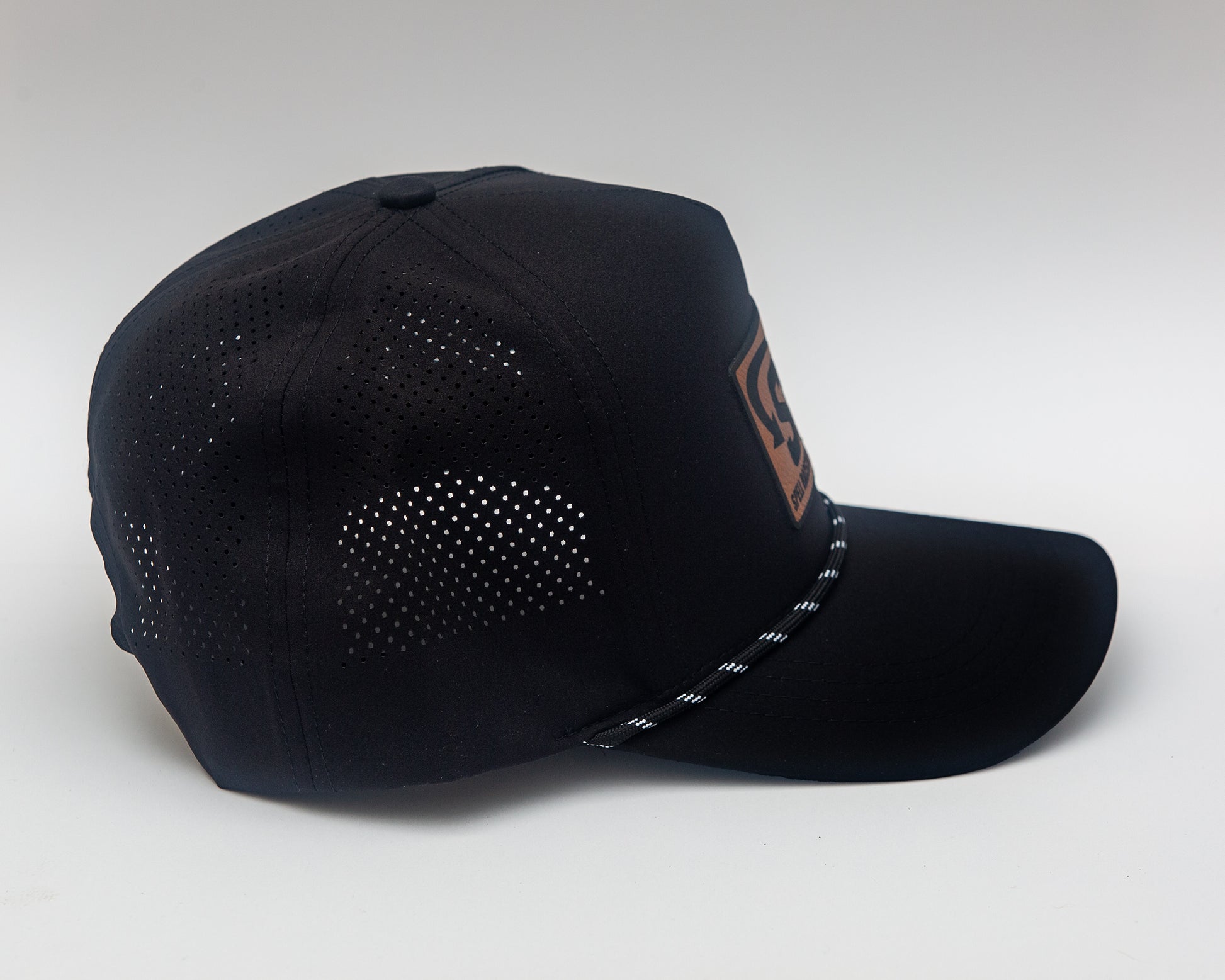side view of black baseball hat with "SRB" on leather patch on white background