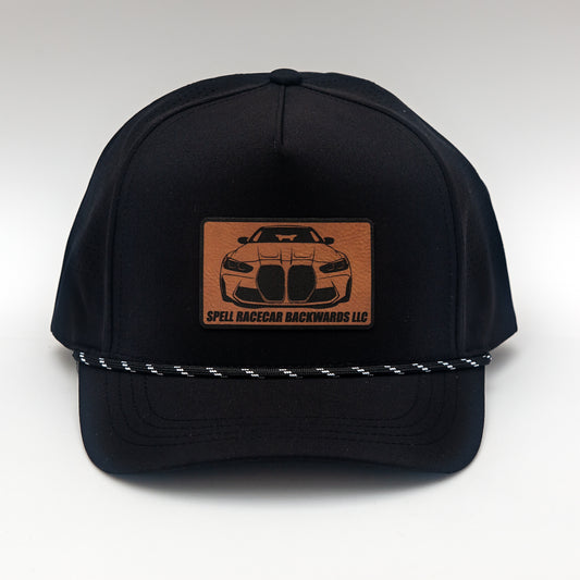 front view of black ball cap with leather patch with front view illustration of car, photographed on white background