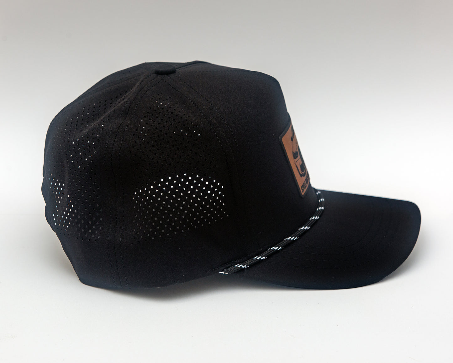 side view of black ball cap with leather patch with front view illustration of car, photographed on white background